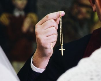 man holding cross pendant